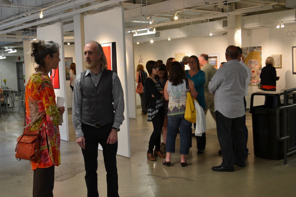 A group of people standing in an art gallery.