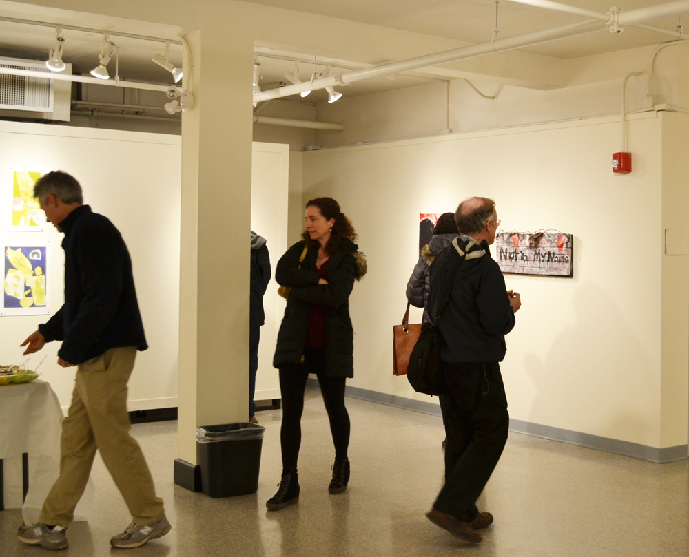 A group of people standing in an art gallery.