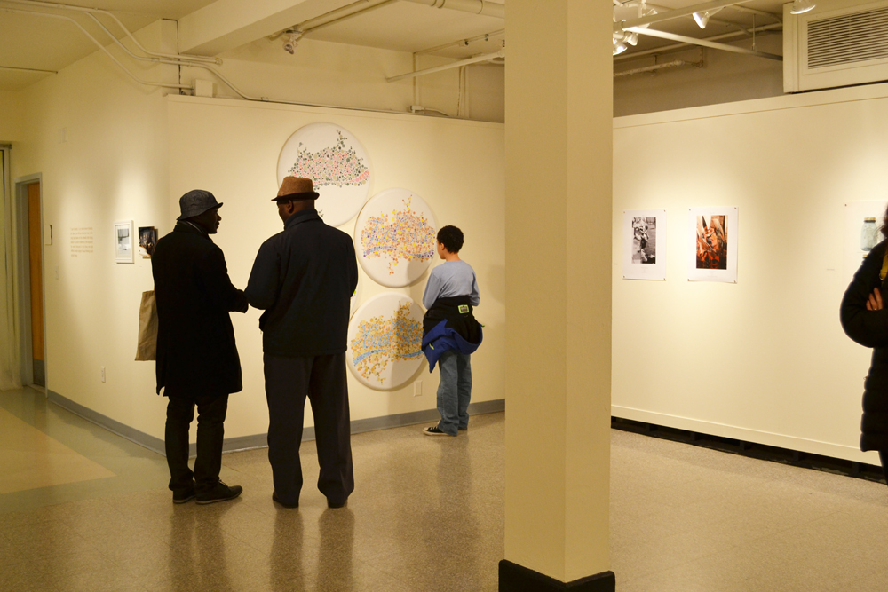 A group of people standing in an art gallery.