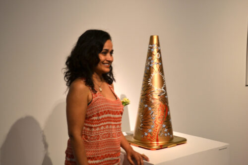 A woman standing next to an orange cone.
